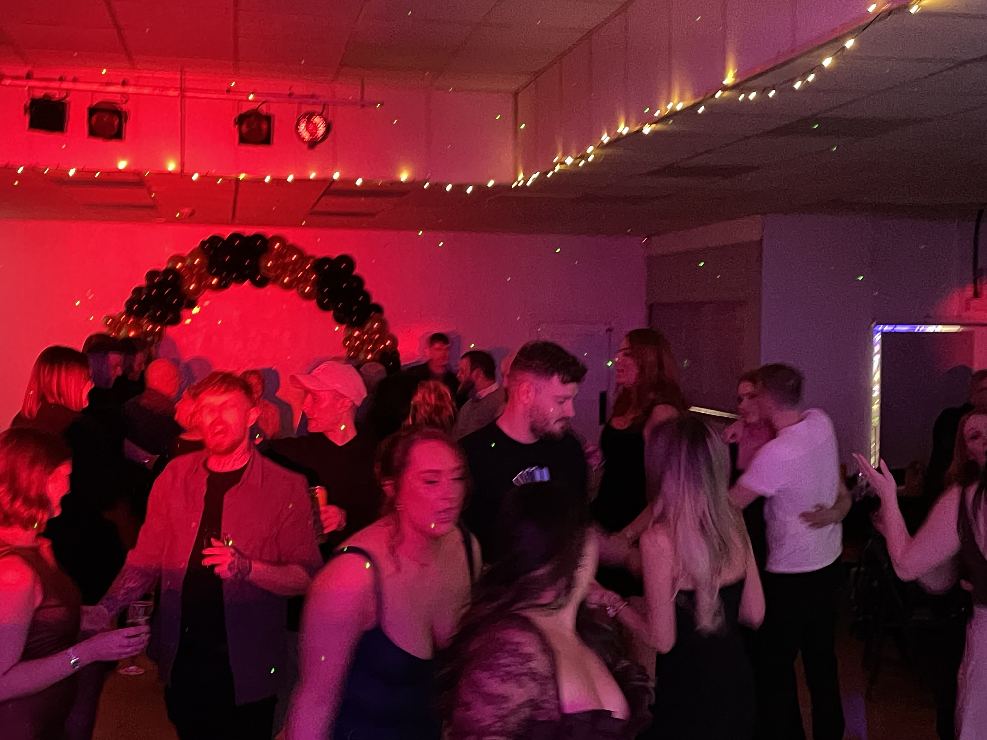 Silhouettes of dancers moving under dramatic green and purple stage lighting